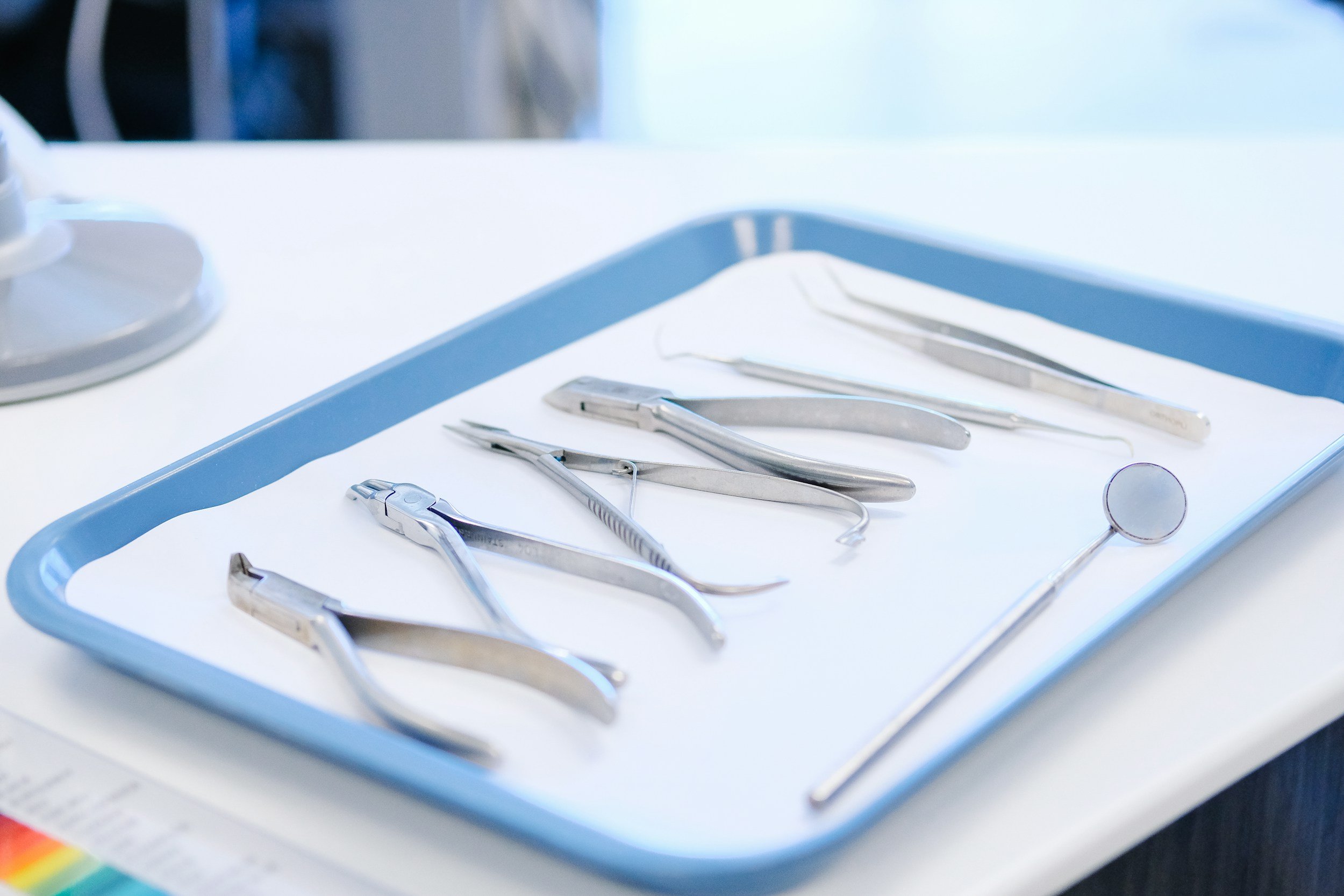 Dental instruments arranged on a light blue medical tray